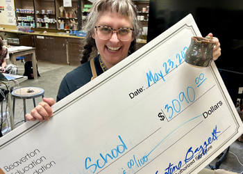 Beaverton district school teacher with BEF check