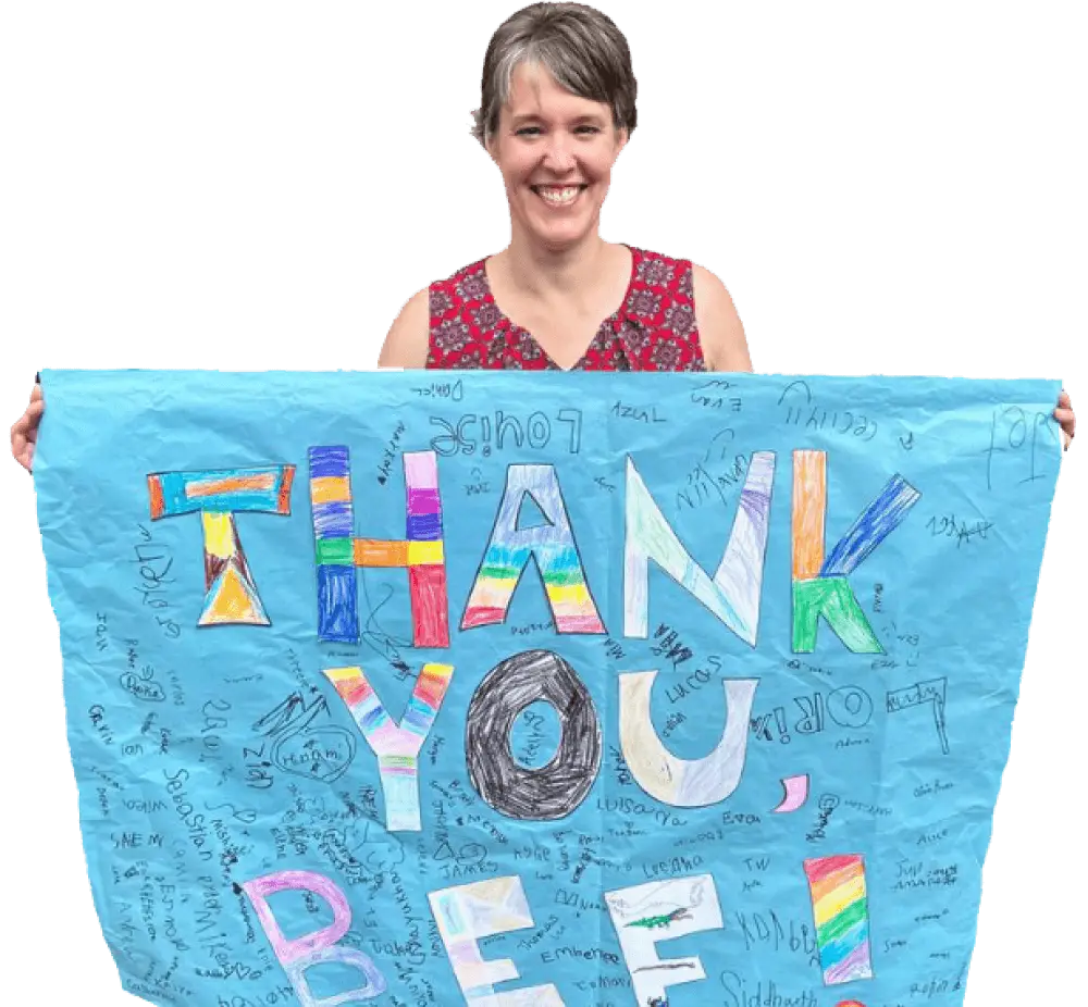 a Beaverton principal carrying a poster with THANK YOU BEF! and kids' signatures surrounding it.