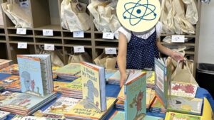 Girl selecting books for Summer Boost book bag.