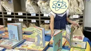 Girl selecting books for Summer Boost book bag.
