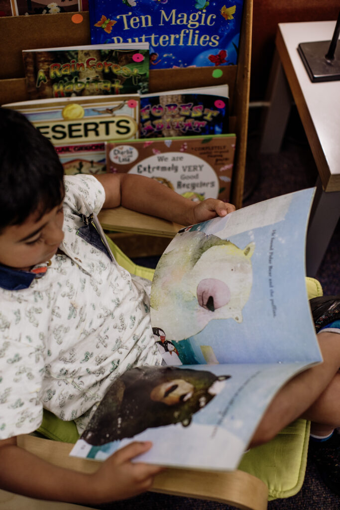 Kindergarten student at Raleigh Park Elementary reading a book