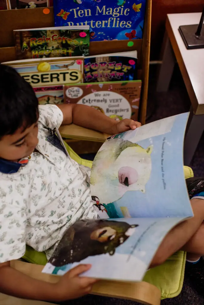 Kindergarten student at Raleigh Park Elementary reading a book