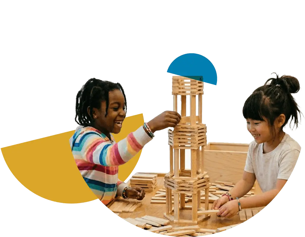 Two elementary girls building with Keva Planks