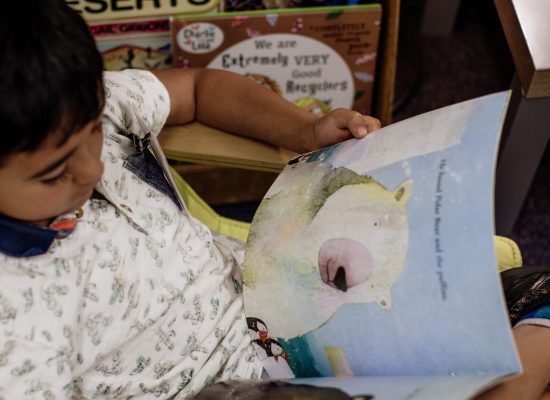 Kindergarten student at Raleigh Park Elementary reading a book