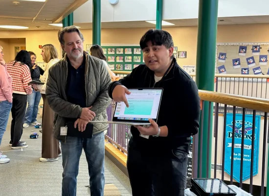 Analog Devices' Jose Garcia looks on as a TIA explains how robots can be used in the classroom